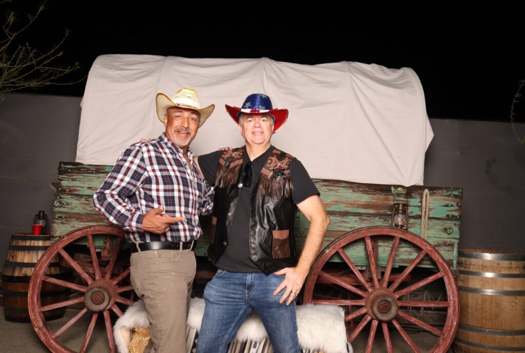 Jorge & Laurent in front of a covered wagon. Photo taken by Coachella Party vintage booth.