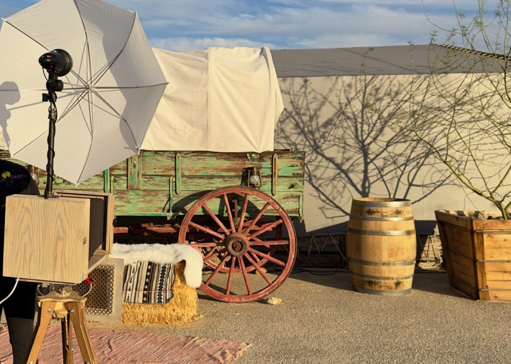 Coachella Party vintage booth in front of an old rustic covered wagon